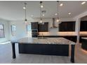 Stunning kitchen features an oversized granite island, stainless hood, and sleek dark cabinetry at 2546 E Russell St, Mesa, AZ 85213