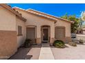 Low angle view of a home's front entrance featuring desert landscaping and a secured front door with sidelight windows at 2635 E Riviera Dr, Chandler, AZ 85249