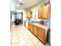 Spacious kitchen with wood cabinets, tile flooring, and a view into the dining area at 2635 E Riviera Dr, Chandler, AZ 85249