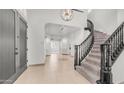 Grand foyer featuring a curved staircase, elegant lighting, and neutral tile flooring at 3166 E Desert Willow Rd, Phoenix, AZ 85048