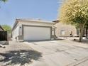 View of the home's facade with a large driveway leading to the two-car garage and neutral desert landscaping at 365 E Mountain View Rd, San Tan Valley, AZ 85143