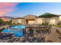 Backyard pool features a bar with seating and an umbrella for outdoor enjoyment at 37308 N 100Th Pl, Scottsdale, AZ 85262