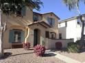 Charming two-story home with a well-manicured front yard, colorful flower beds and turquoise accents at 4056 E Devon Dr, Gilbert, AZ 85296