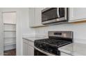 Stylish kitchen with stainless steel gas range, microwave, and quartz countertops at 5865 E Axle Ln, San Tan Valley, AZ 85140