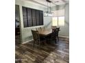 Stylish dining room with wood-look tile flooring and a modern light fixture at 6808 W Maldonado Rd, Laveen, AZ 85339