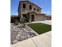 Landscaped front yard with rocks, turf, and palm trees create an inviting curb appeal at 6808 W Maldonado Rd, Laveen, AZ 85339