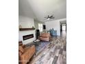 Cozy living room with a fireplace, ceiling fan, and wood-look tile flooring at 6808 W Maldonado Rd, Laveen, AZ 85339