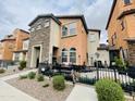 Two-story home featuring a stone facade, front patio, and wrought iron fence at 7734 W Terri Lee Dr, Phoenix, AZ 85035
