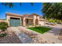 Charming single-story home with stucco siding, tile roof, green lawn, and a decorative blue fence at 800 W Sycamore Ct, Litchfield Park, AZ 85340