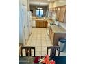 Open kitchen featuring neutral countertops, tiled floors, and appliances, seamlessly blending into other rooms at 13783 W Caribbean Ln, Surprise, AZ 85379