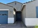 Inviting entrance with brick walkway and covered porch, leading to a blue front door at 17788 W Odeum Ln, Goodyear, AZ 85338