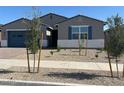 Charming single-story home featuring a blue garage door and a desert landscape at 17788 W Odeum Ln, Goodyear, AZ 85338