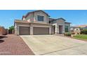 Expansive exterior elevation featuring a three-car garage, and well-manicured landscaping at 2036 S Reseda Ct, Gilbert, AZ 85295