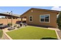 Backyard features a small patio, desert landscaping and artificial grass at 22560 E Rosa Rd, Queen Creek, AZ 85142
