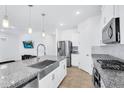 Modern kitchen with stainless steel appliances, granite countertops, and a stylish farmhouse sink at 22560 E Rosa Rd, Queen Creek, AZ 85142