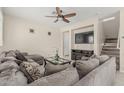 Cozy living room featuring a large sectional sofa, ceiling fan, and entertainment center with fireplace at 2559 N 73Rd Dr, Phoenix, AZ 85035