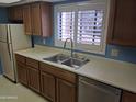 A kitchen featuring stainless steel sink and appliances, paired with neutral counters and traditional wood cabinets at 3031 N Civic Center Plz # 113, Scottsdale, AZ 85251