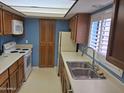 Galley kitchen with white appliances, light countertops, and oak wood cabinetry at 3031 N Civic Center Plz # 113, Scottsdale, AZ 85251