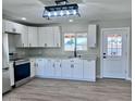 Bright, modern kitchen boasts white cabinets, quartz countertops, stainless steel appliances, and a view to the backyard at 3049 W Dahlia Dr, Phoenix, AZ 85029