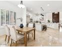 Open concept kitchen featuring white cabinets, center island, and dining area at 3221 E Lynx Pl, Chandler, AZ 85249