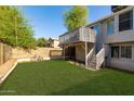 The backyard features a well-kept lawn, a raised wooden deck, and mature trees, perfect for relaxation at 3755 E Broadway Rd # 36, Mesa, AZ 85206