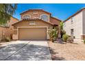 Two-story home with a two-car garage and desert landscaping under a clear blue sky at 4034 E Mine Shaft Rd, San Tan Valley, AZ 85143