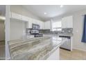 Bright kitchen featuring stainless steel appliances, granite countertops, and a stylish backsplash at 41388 W Hopper Dr, Maricopa, AZ 85138