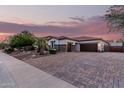 A charming single-story home with a three-car garage and a brick-paved driveway at 4282 N 180Th Dr, Goodyear, AZ 85395