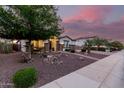 Charming single-story home featuring decorative rock landscaping and mature trees in the front yard at 4282 N 180Th Dr, Goodyear, AZ 85395