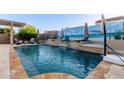 Backyard pool featuring a waterfall feature, lounge chairs, and a mural on the privacy wall at 4282 N 180Th Dr, Goodyear, AZ 85395