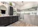 Sleek primary bath with dual vanities, soaking tub, and glass-enclosed shower with grey tile at 4706 E Des Moines St, Mesa, AZ 85205