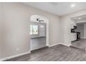 Open-concept living space with wood-style floors flows into kitchen through an arched doorway at 4750 N 50Th Ave, Phoenix, AZ 85031