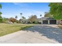 Beautifully landscaped front yard with circular driveway leading to the traditional white brick home and garage at 5339 E Osborn Rd, Phoenix, AZ 85018