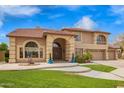 Charming home exterior showcasing a manicured lawn, mature landscaping, and a spacious three-car garage with ample parking at 5510 N 132Nd Dr, Litchfield Park, AZ 85340