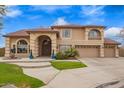 Beautiful home exterior featuring a well-maintained lawn, mature landscaping, and a spacious driveway leading to a three-car garage at 5510 N 132Nd Dr, Litchfield Park, AZ 85340