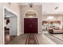 Elegant foyer with high ceilings, decorative chandelier, rich double door entrance, and views into the formal living space at 5510 N 132Nd Dr, Litchfield Park, AZ 85340
