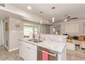 Updated kitchen with granite countertops, a stainless steel dishwasher, and open views to the living area at 5913 E Thomas Rd, Scottsdale, AZ 85251