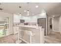 Bright kitchen features white cabinets, granite countertops, stainless appliances, and breakfast bar with stylish pendant lights at 5913 E Thomas Rd, Scottsdale, AZ 85251