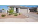 Inviting single-story home boasts desert landscaping, a paved driveway, and a two-car garage, enhancing its curb appeal at 6117 S Adelle --, Mesa, AZ 85212