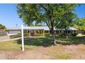Charming single-story home with a well-maintained lawn, flowering shrubs, and a bright yellow front door at 7042 N 13Th St, Phoenix, AZ 85020