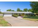 A single-story home with an extended driveway, attached garage, and a neatly landscaped front yard at 7042 N 13Th St, Phoenix, AZ 85020