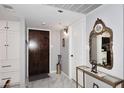 Inviting entryway with marble floors, decorative mirror, and convenient coat storage at 7950 E Camelback Rd # 308, Scottsdale, AZ 85251