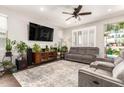 Inviting living room with plush seating, a large television, stylish ceiling fan, and plenty of plants at 8418 W Palmaire Ave, Glendale, AZ 85305