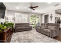 Cozy living room with dual couches, a large window with shutters, and a view to the outdoor patio at 8418 W Palmaire Ave, Glendale, AZ 85305