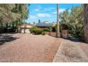 Beautiful home showcasing a two-car garage, desert landscaping, solar panels, and mature trees at 8637 E Appaloosa Trl, Scottsdale, AZ 85258