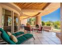 Inviting outdoor patio with fireplace, seating, and lush landscaping offering a relaxing space for entertaining at 10901 E Quarry E Trl, Scottsdale, AZ 85262