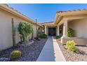 Inviting front entrance showcasing a pathway leading to double doors with decorative cacti and shrubs at 13305 W Colter St, Litchfield Park, AZ 85340