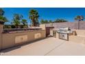 Well-equipped outdoor kitchen with a built-in barbecue grill, sink, and storage cabinets for entertaining at 13305 W Colter St, Litchfield Park, AZ 85340