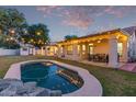 Backyard with a private pool, patio, dining set, lush lawn and beautiful desert landscaping at 13629 N 71St Dr, Peoria, AZ 85381