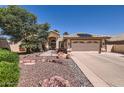 Inviting home featuring a two-car garage, desert landscaping, and solar panels at 14680 W Morning Star Trl, Surprise, AZ 85374